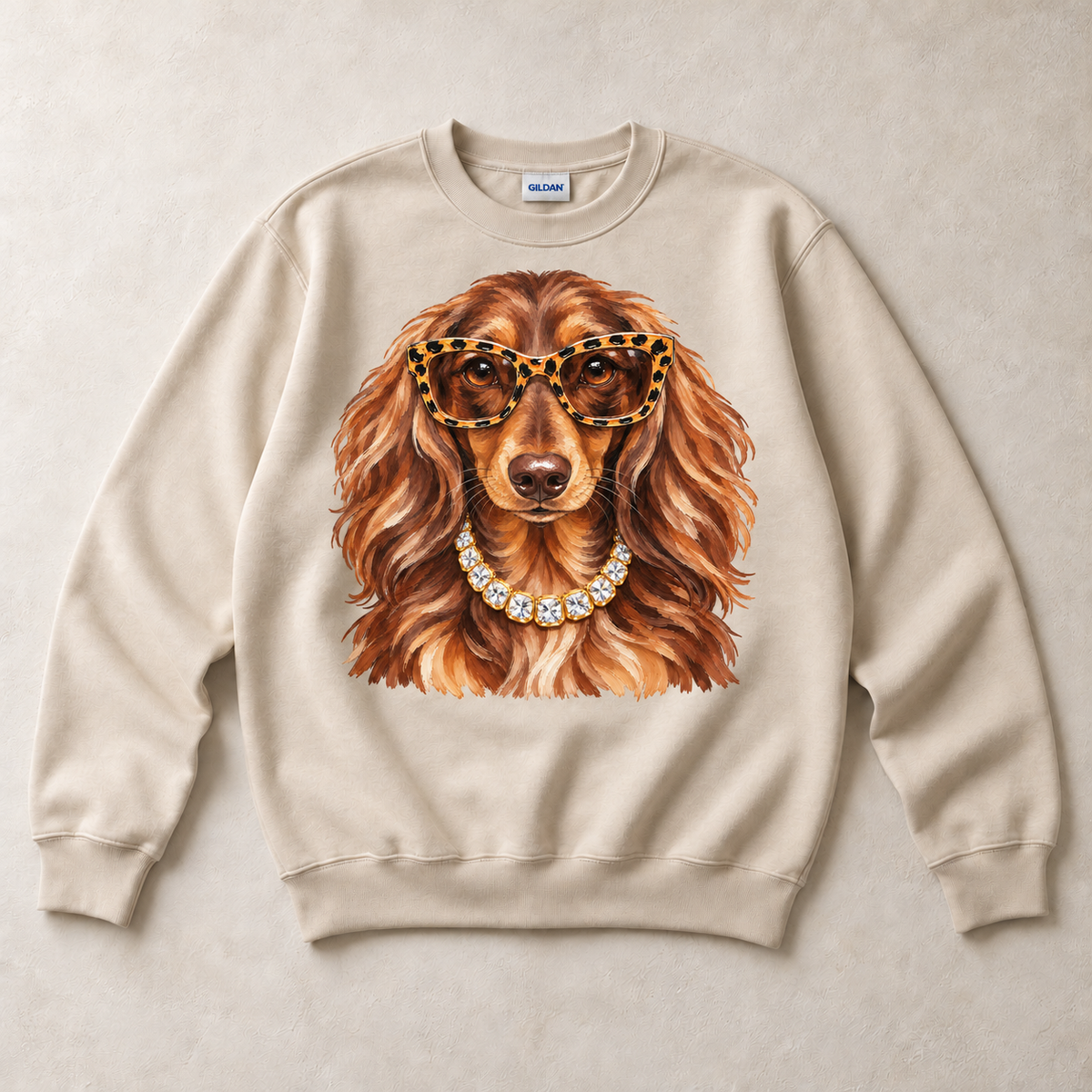 Sand Gildan crewneck sweatshirt with Dachshund Leopard Glasses graphic, front flat lay