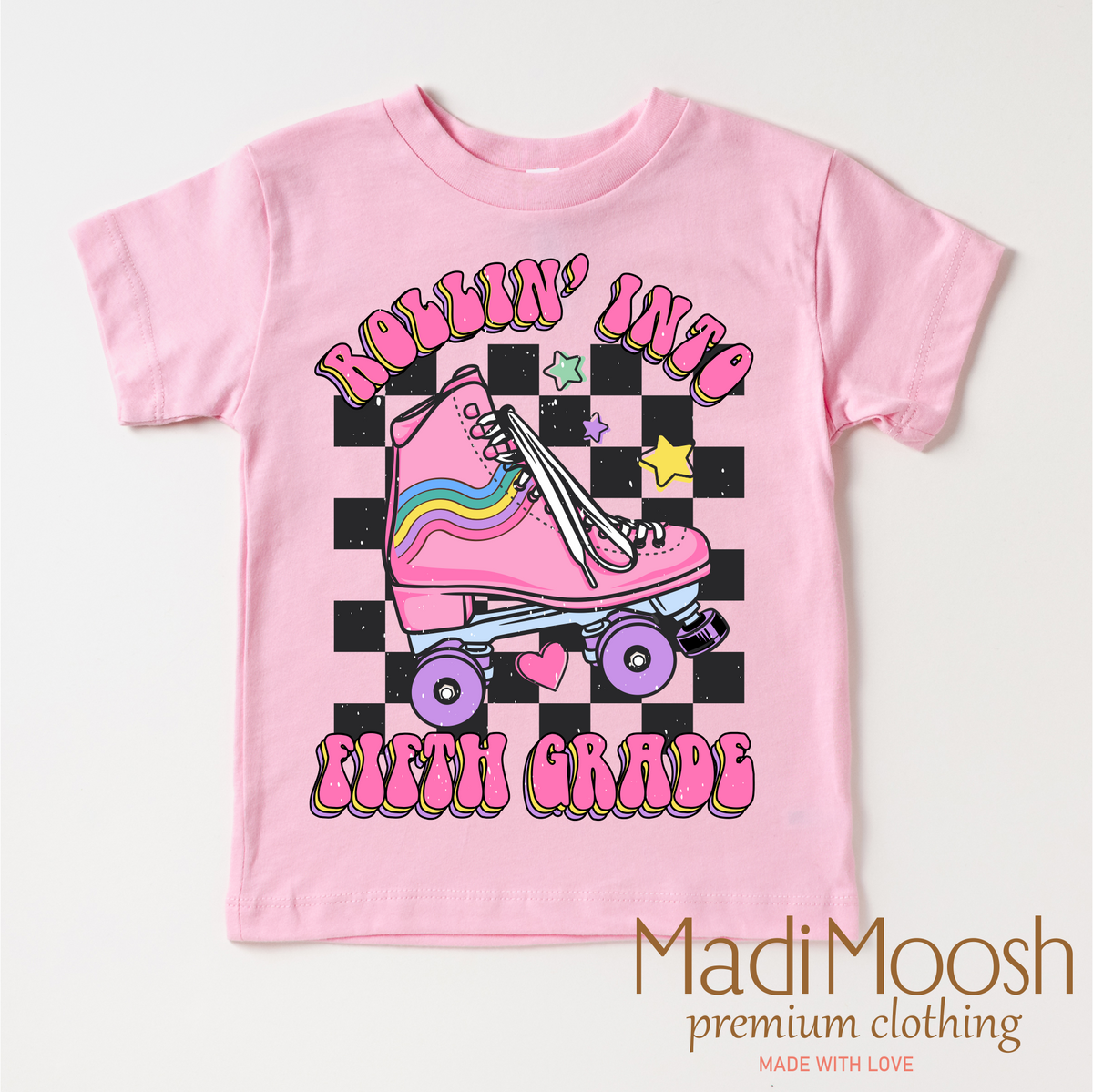 Rollin Into Fifth Grade Back To School design on a pink garment.