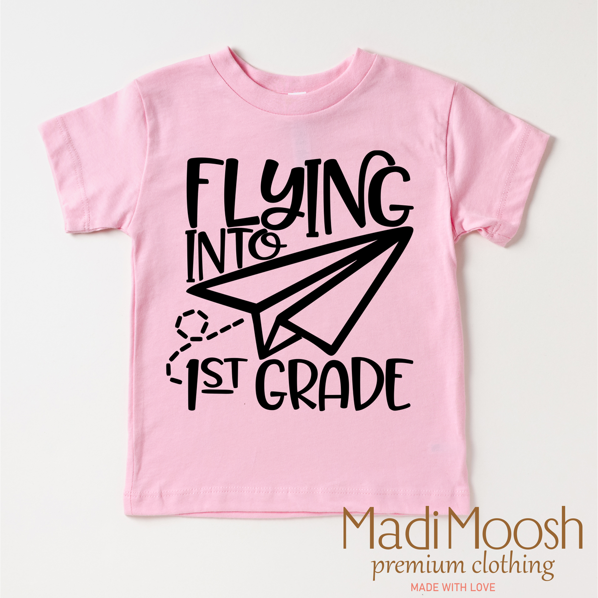 Flying Into First Grade Back To School design on a pink garment.