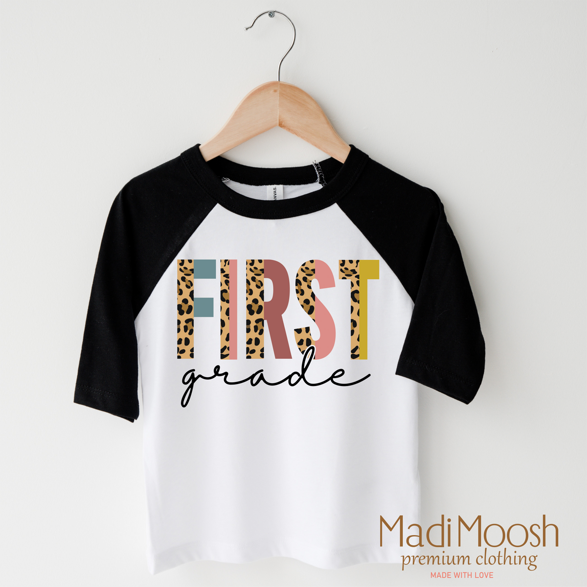 First Grade Leopard design on a raglan shirt with black sleeves.