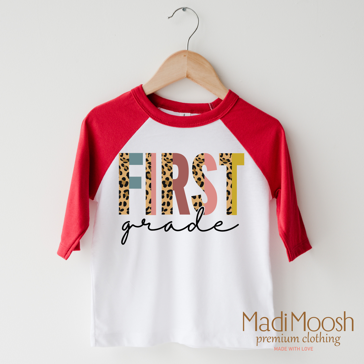 First Grade Leopard design on a raglan shirt with red sleeves.