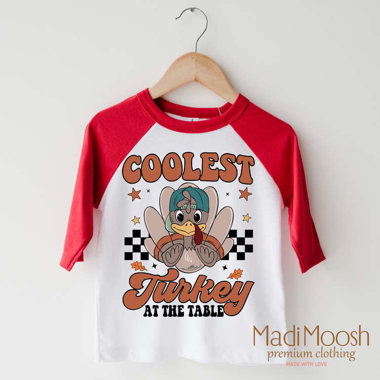Coolest Turkey At The Table design on a raglan shirt with red sleeves.