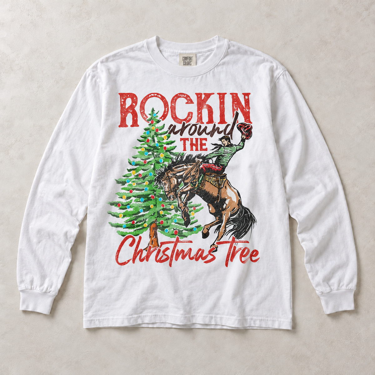 White Comfort Colors long-sleeve tee featuring Rockin Around the Christmas Tree cowboy and bucking horse graphic