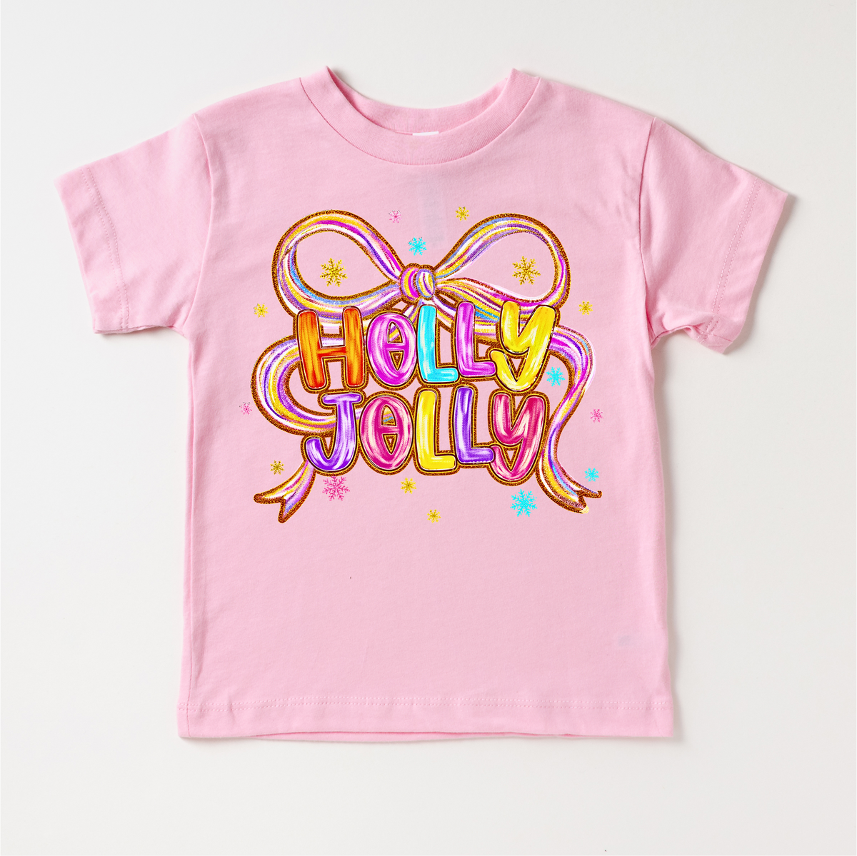 Holly Jolly Ribbon Christmas design on a pink garment.