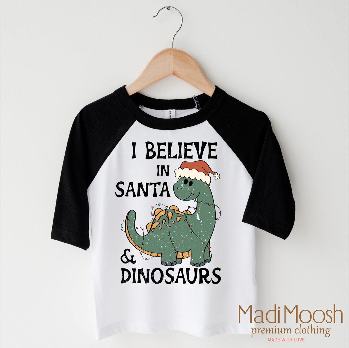 I Believe In Santa And Dinosaurs Christmas design on a black-accented shirt.