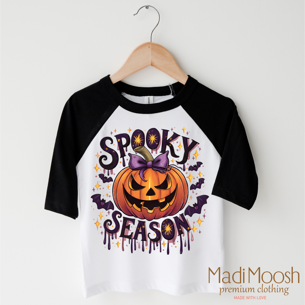 Spooky Season Pumpkin design on a black-accented shirt.