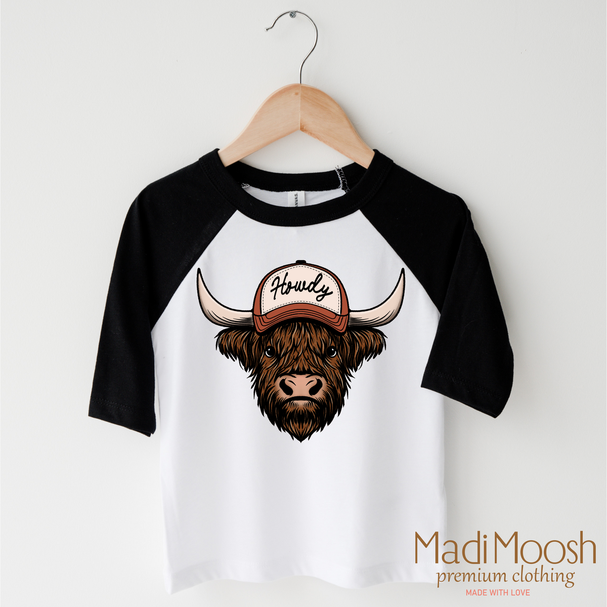 Howdy Highland Cow Western design on a black-accented shirt.