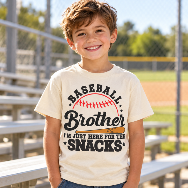 Generated lifestyle mockup of the Baseball Brother I'm Just Here for the Snacks shirt in Natural at the ballpark.