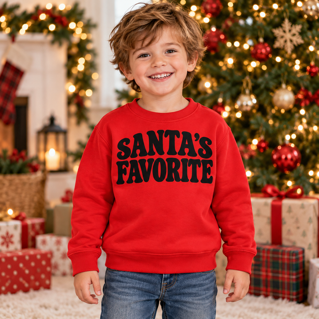 Boy wearing a red Santa's Favorite Retro Christmas sweatshirt in a festive Christmas setting