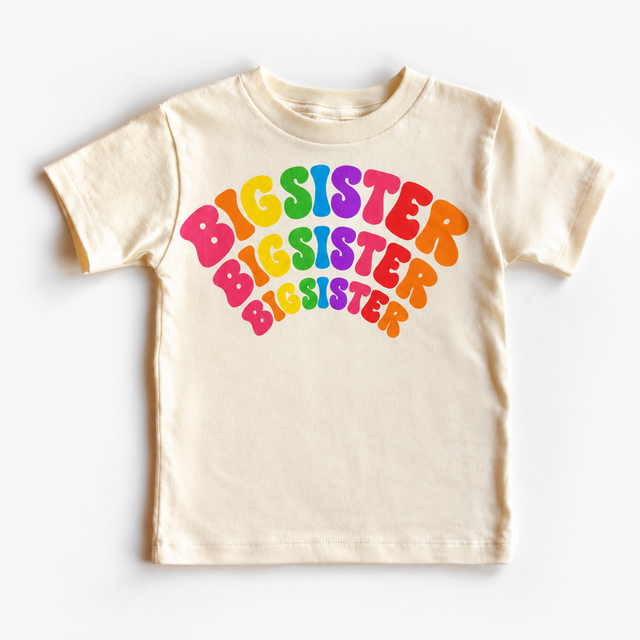 Big Sister rainbow arched lettering on a natural tee