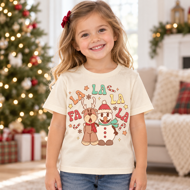 Child wearing natural Fa La La La Christmas Shirt in a festive Christmas setting