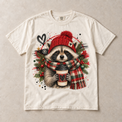 Ivory Comfort Colors short-sleeve T-shirt with Christmas Raccoon Coffee graphic, front flat lay
