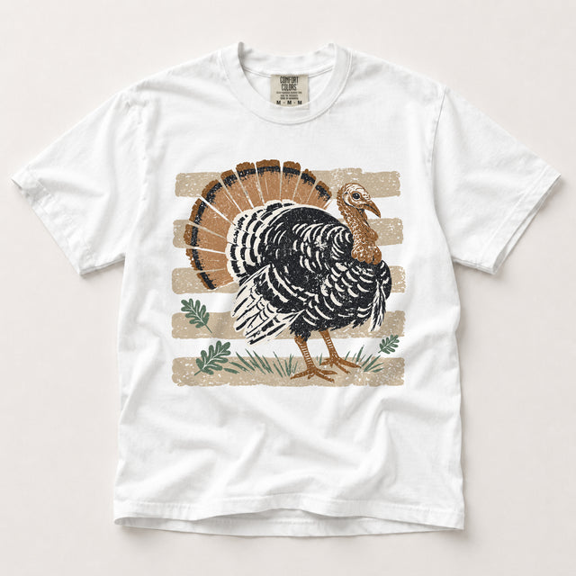 White Comfort Colors T-shirt featuring a vintage black and brown turkey with tan stripes and green autumn leaves