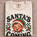 Natural Comfort Colors Santa's Coming Shirt folded on wood