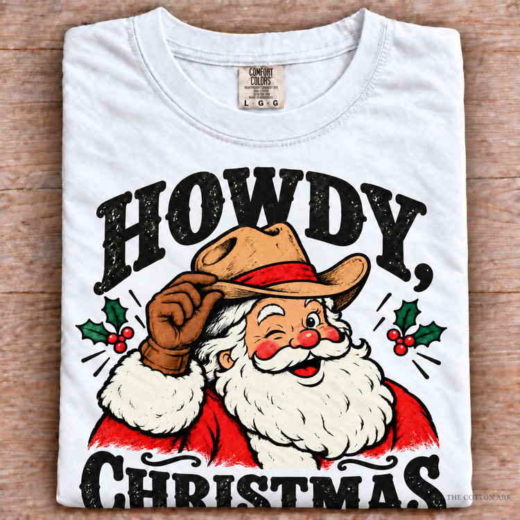 White Comfort Colors Howdy Christmas Shirt folded on wood