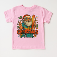 Christmas Vibes Surfing Santa design on a pink garment.