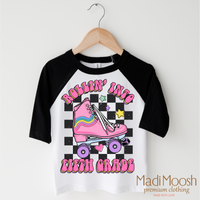 Rollin Into Fifth Grade Back To School design on a black-accented shirt.