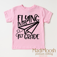 Flying Into First Grade Back To School design on a pink garment.