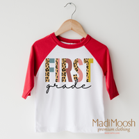 First Grade Leopard design on a raglan shirt with red sleeves.