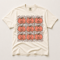 Retro jack-o'-lantern and daisy grid graphic on an ivory Comfort Colors T-shirt