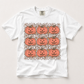 Retro jack-o'-lantern and daisy grid graphic on a white Comfort Colors T-shirt