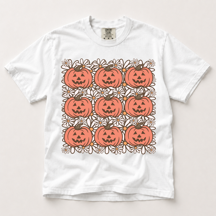 Retro jack-o'-lantern and daisy grid graphic on a white Comfort Colors T-shirt