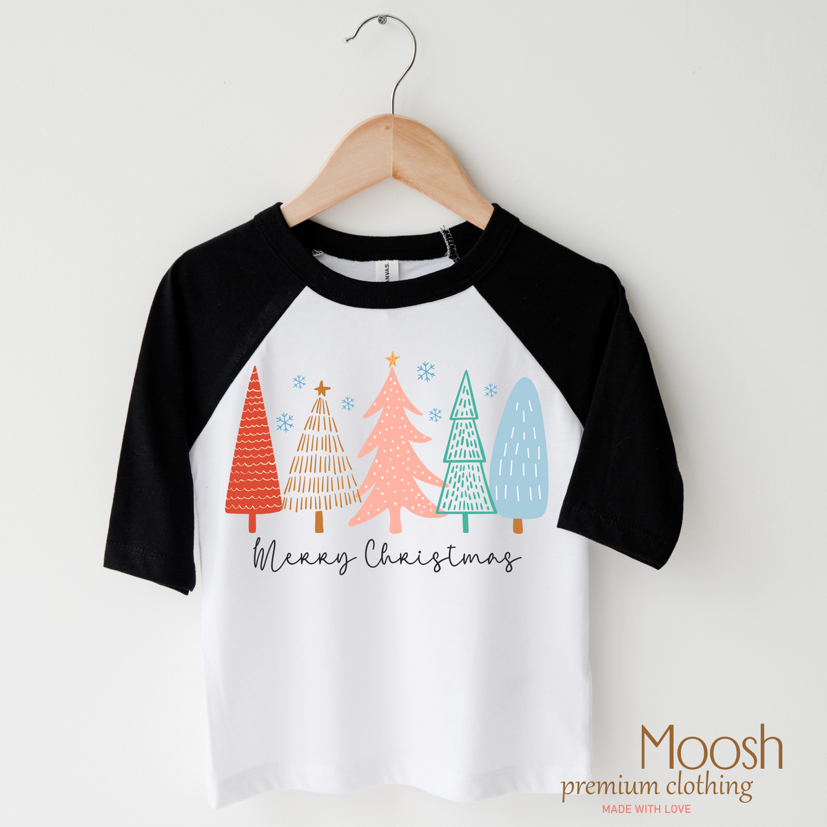 Merry Christmas Trees design on a raglan shirt with black sleeves.