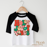 Holly Jolly Vibes design on a raglan shirt with black sleeves.