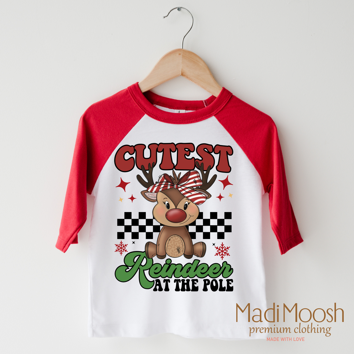 Cutest Reindeer at the Pole design on a red-accented shirt.