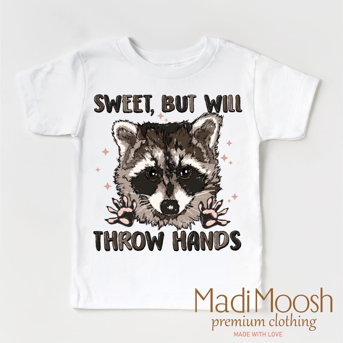 Sweet But I Throw Hands Raccoon design on a white garment.