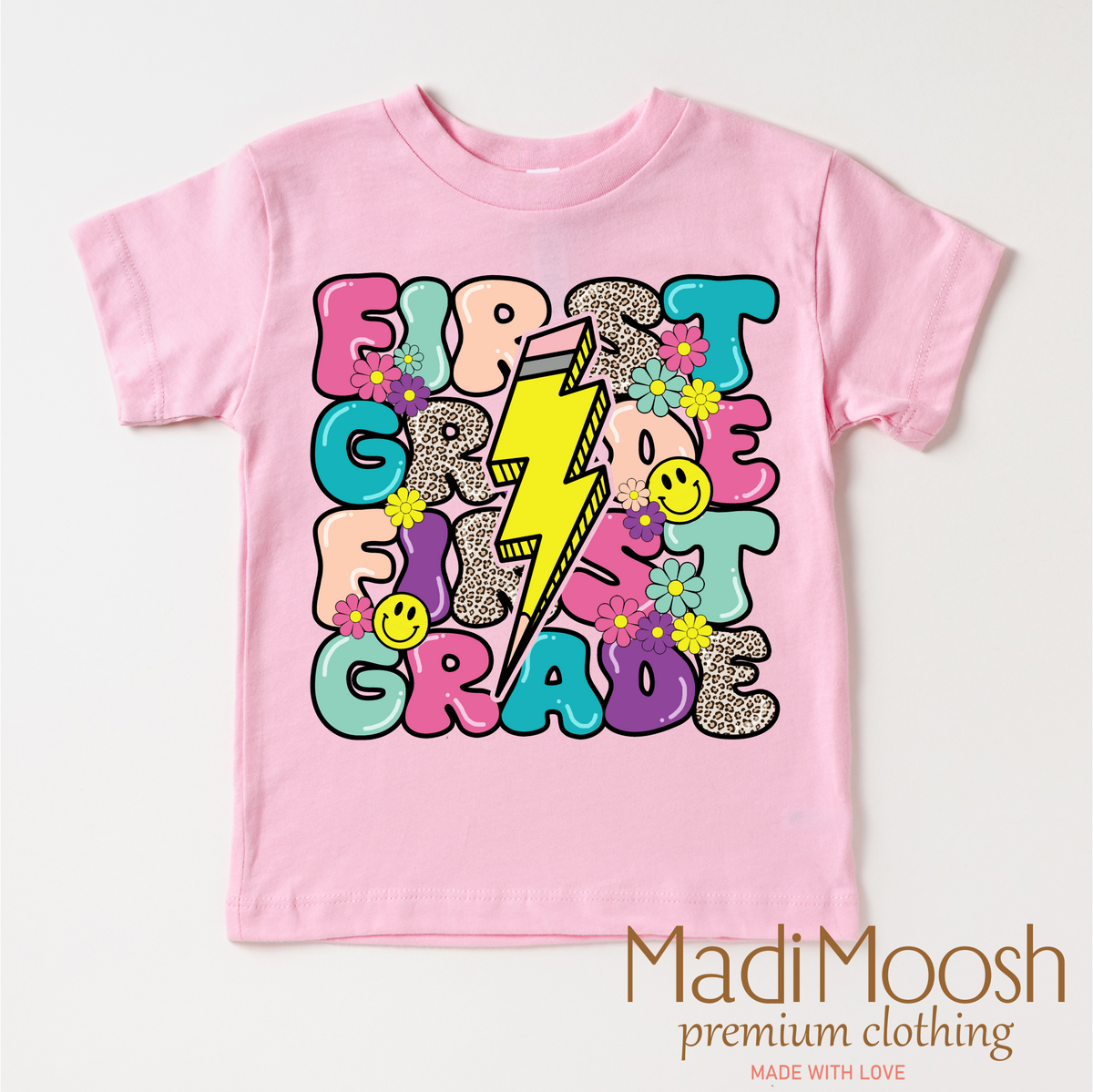 First Grade Lightning Bolt Back To School design on a pink garment.