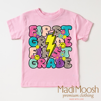 First Grade Lightning Bolt Back To School design on a pink garment.