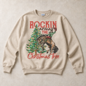 Sand Gildan sweatshirt featuring Rockin Around the Christmas Tree cowboy and bucking horse graphic