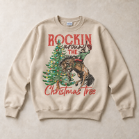 Sand Gildan sweatshirt featuring Rockin Around the Christmas Tree cowboy and bucking horse graphic