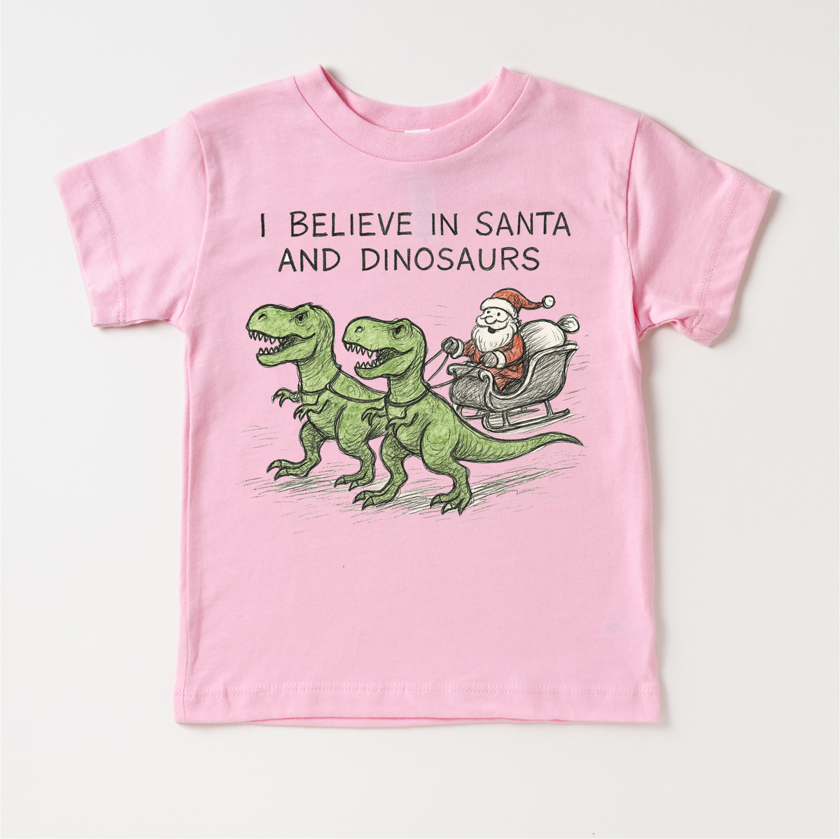 I Believe In Santa And Dinosaurs Christmas design on a pink garment.