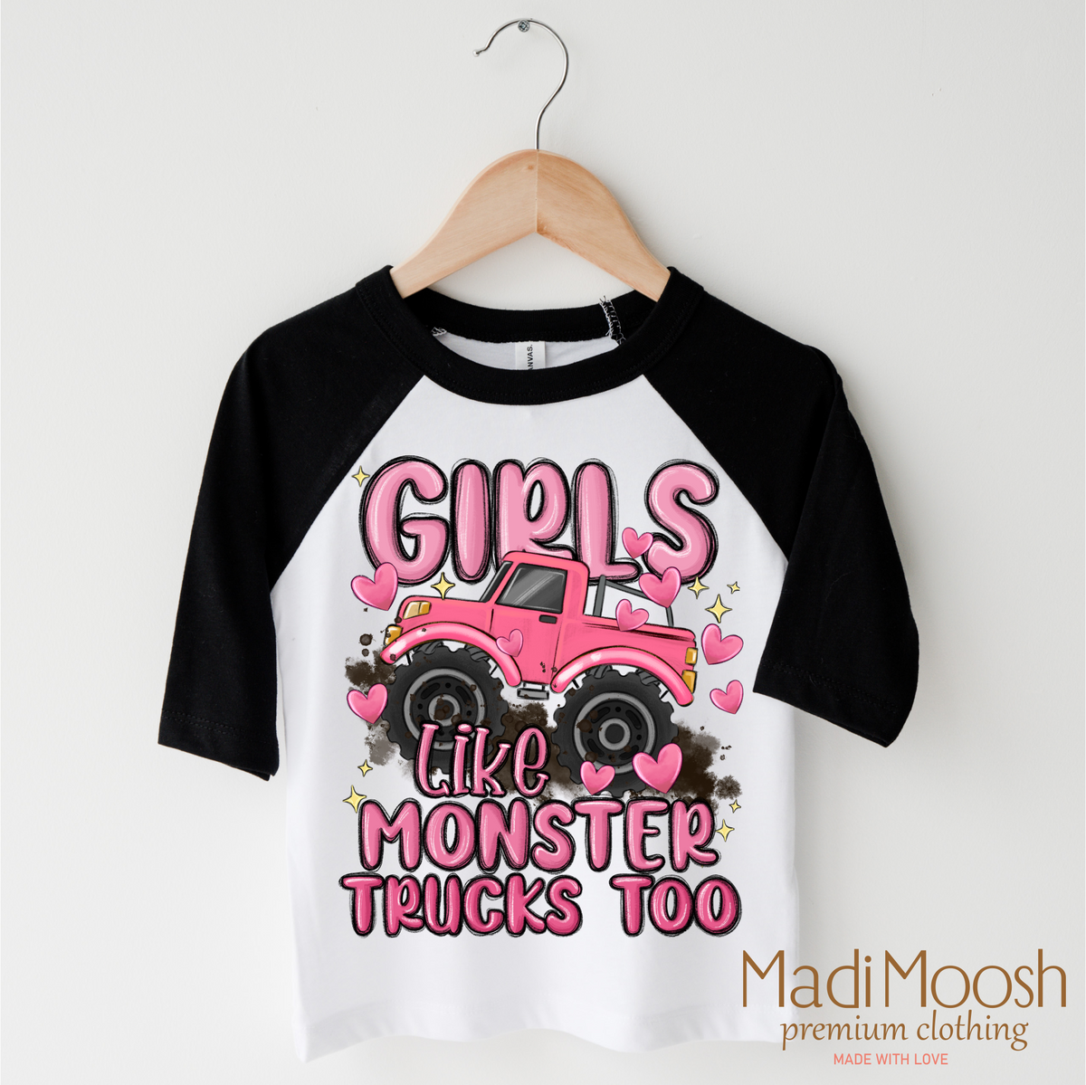 Girls Like Monster Trucks Too design on a black-accented shirt.