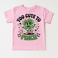 Too Cute To Pinch St. Patrick's Day design on a pink garment.