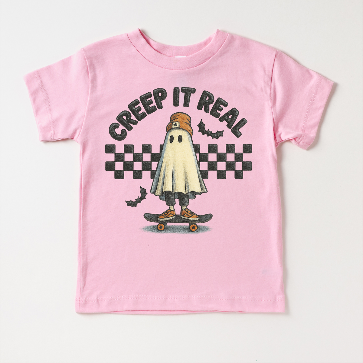 Retro Creep It Reel Skater Halloween design on a pink garment.