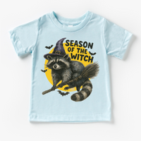 Season Of The Witch Raccoon Halloween design on a blue garment.