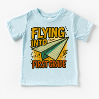 Flying Into First Grade Back To School design on a blue garment.