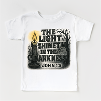 The Light Shineth In The Darkness design on a white garment.