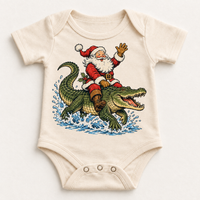 Santa riding an alligator Christmas design on a natural bodysuit by Madi Moosh