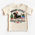 Merry Little Weiner Christmas natural shirt featuring a dachshund in a Santa hat with holiday lights, a tree and gifts.