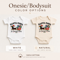 Santa Paws Christmas baby bodysuits in white and natural featuring a dachshund in a Santa hat pulling a sleigh