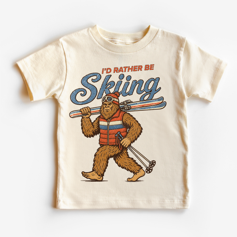 I'd Rather Be Skiing retro Bigfoot carrying skis design on a natural short sleeve tee