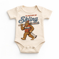 I'd Rather Be Skiing retro Bigfoot carrying skis design on a natural baby bodysuit
