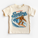 I'd Rather Be Surfing Bigfoot riding a wave design on a natural short sleeve tee