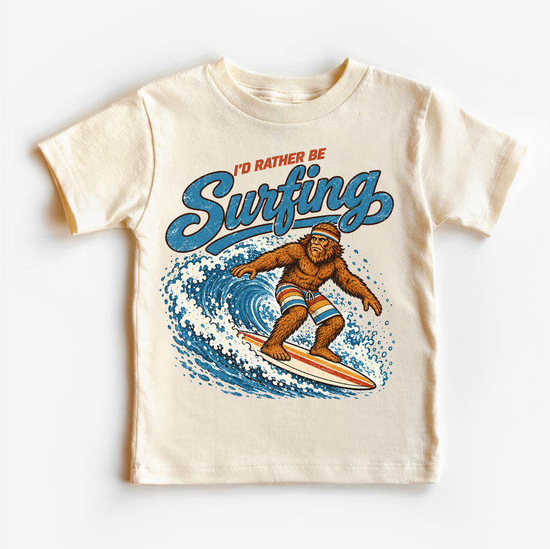 I'd Rather Be Surfing Bigfoot riding a wave design on a natural short sleeve tee