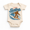 I'd Rather Be Surfing Bigfoot riding a wave design on a natural baby bodysuit