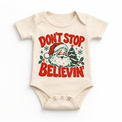 Don't Stop Believin' retro Santa and Christmas tree graphic in red and green on a natural baby bodysuit